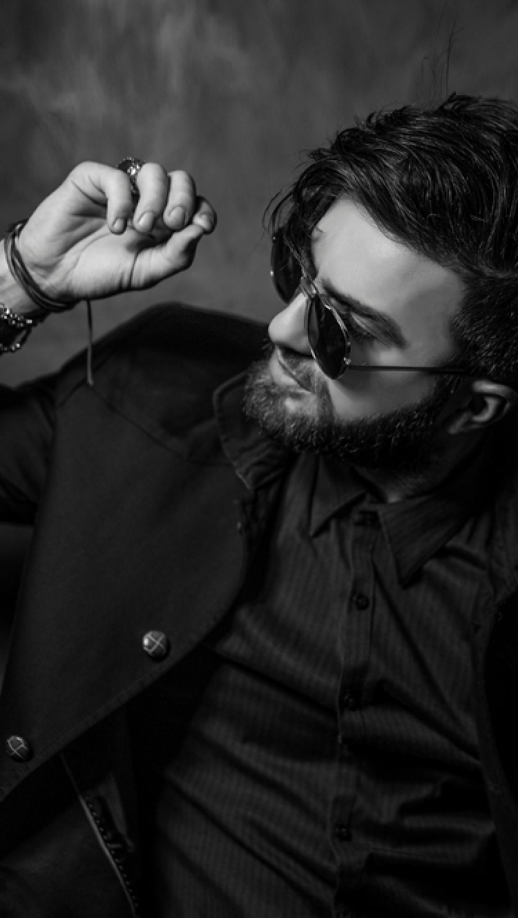 スーツを着たサングラスを掛けている男性がポーズを取っている様子