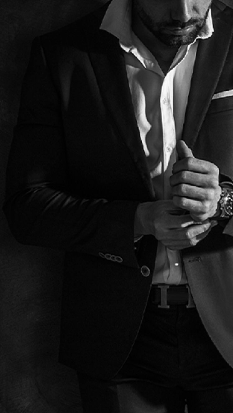 スーツを着た男性が腕時計を身に着けている様子